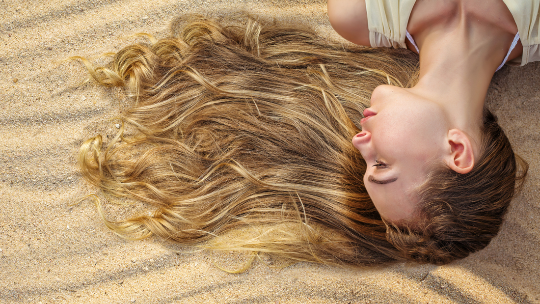 donna sdraiata con i capelli sulla sabbia